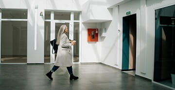 En kvinna går mot en hiss